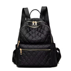 Black quilted backpack with gold zippers on a white background