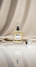 Perfume bottle labeled 'Legacy' on a reflective surface with a beige curtain background