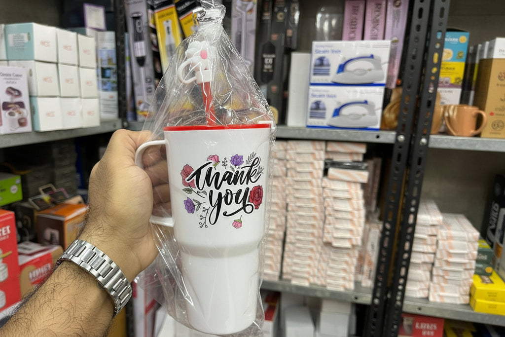 White mug with 'Thank you' design held in a store setting
