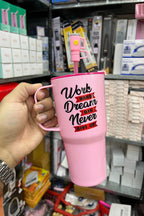 Pink mug with motivational quote held by a hand in a store setting, with 'Jbi' branding visible.