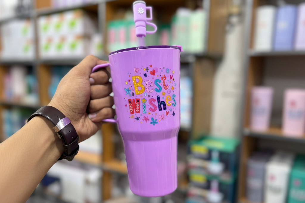 Purple tumbler with 'Best Wishes' text held by a hand in a store setting, with 'Jbi by Smart Deals' logo.