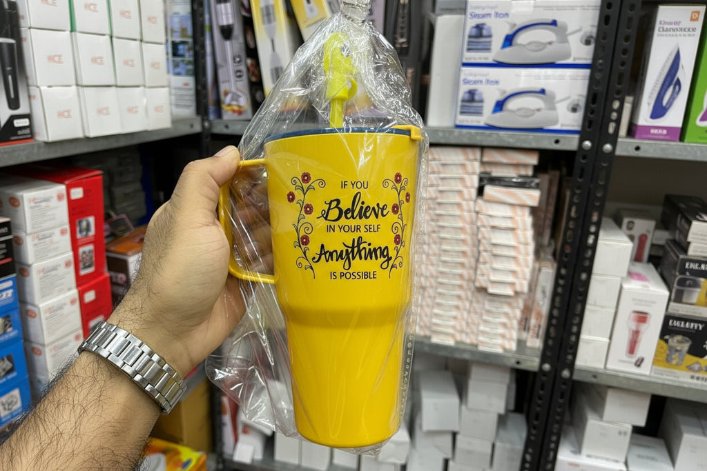Yellow mug with motivational quote held in a hand against a store shelf background