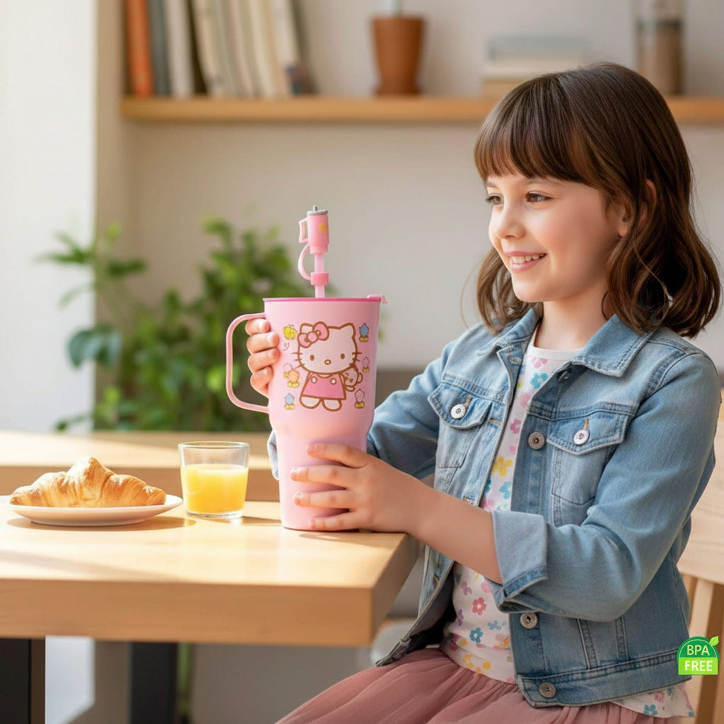 Child holding a pink tumbler with a cartoon character, sitting at a table with a glass of juice and a croissant.