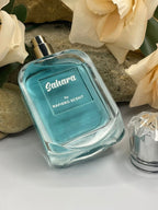 Perfume bottle labeled 'Sahara by Rafiero Scent' with flowers in the background